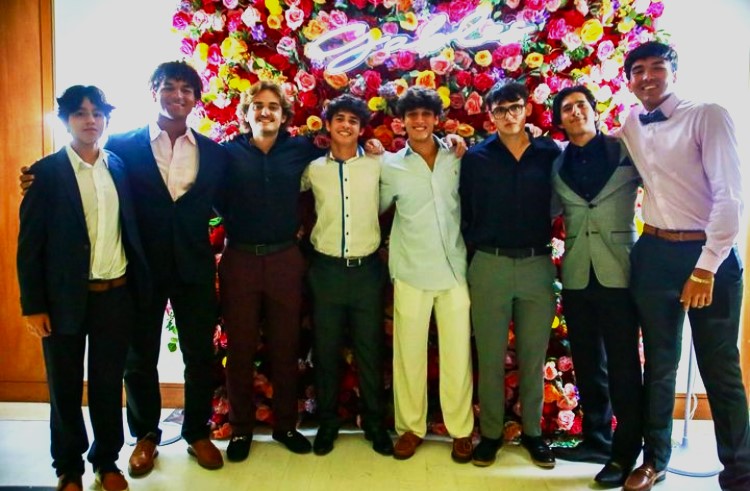 Seniors pose for a picture during Homecoming in front of the roses backdrop, rejoicing in one of the significant social events of their last year of high school.